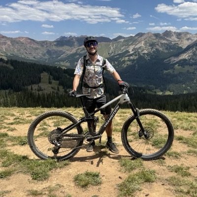 Daniel K. with his bike on a high saddle above Crested Butte